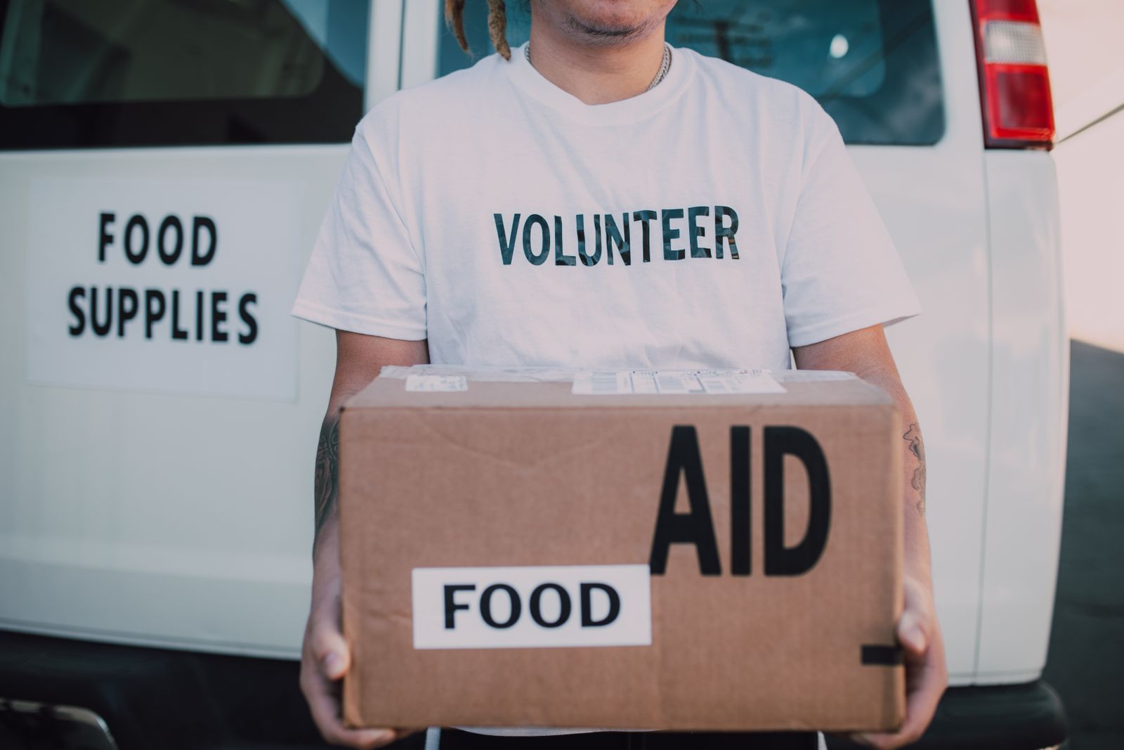 A volunteer carrying a box of food